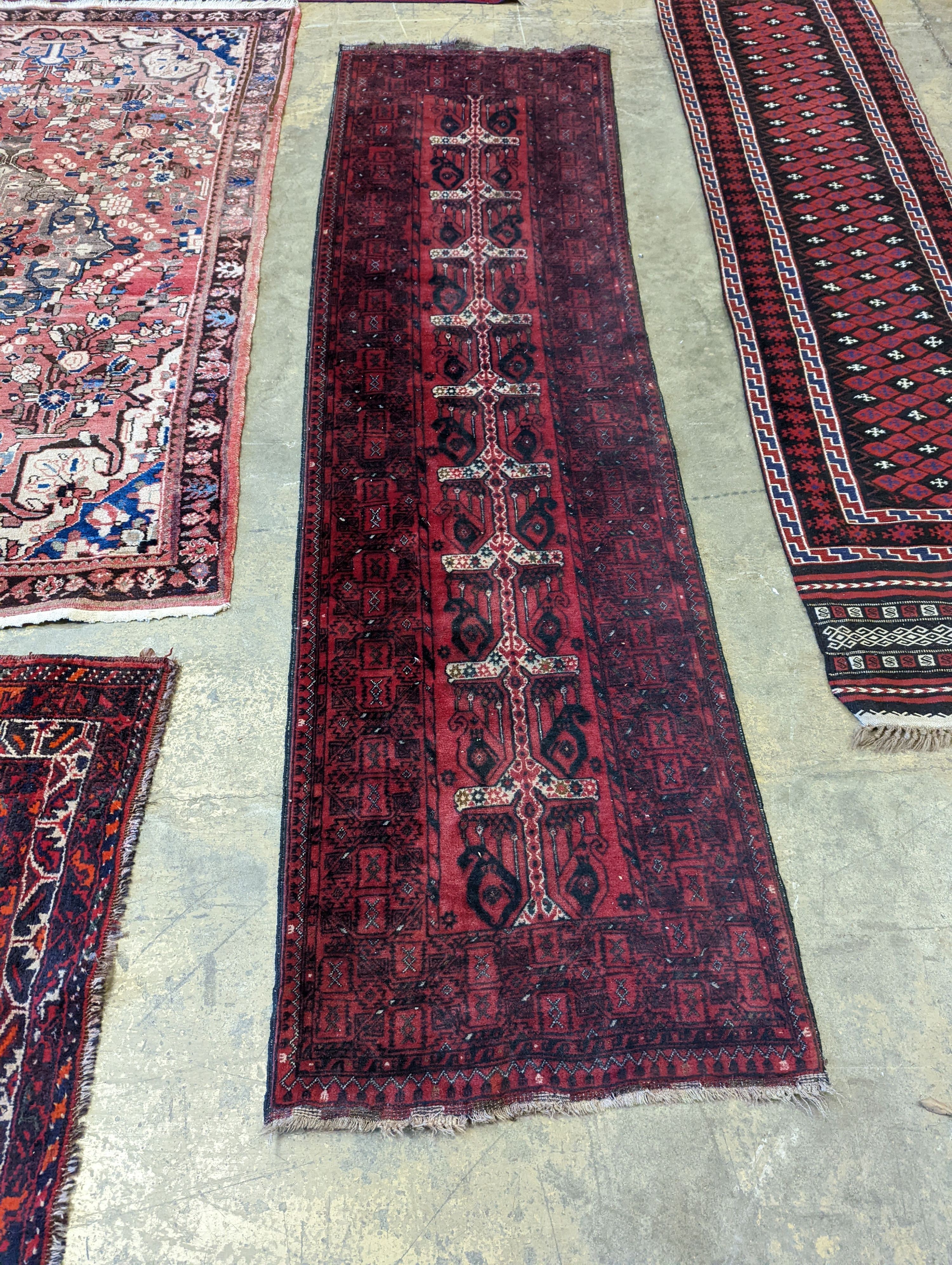 A Belouch red ground runner, 274 x 77cm